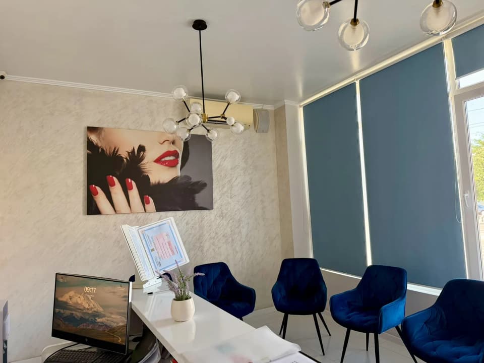 Sala de așteptare a clinicii dentare Daisy Fetești, cu fotolii albastre și lumină naturală
